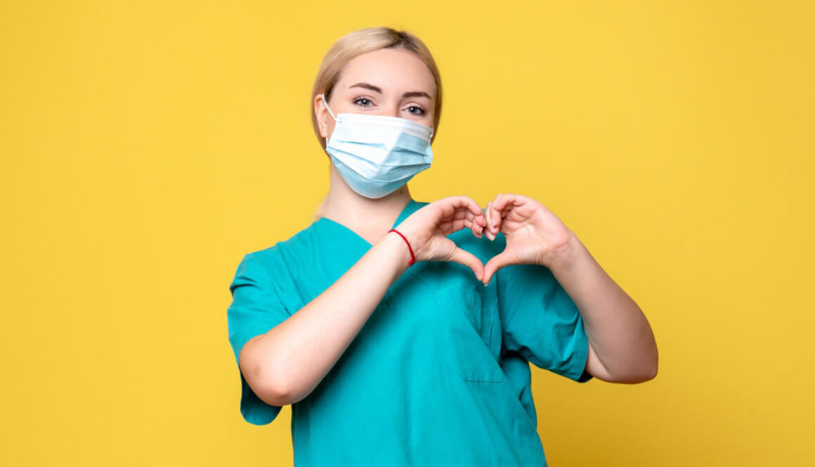 pielęgniarka Pflegefachfrau w masce chirurgicznej robiąca z pomocą dłoni kształt serca